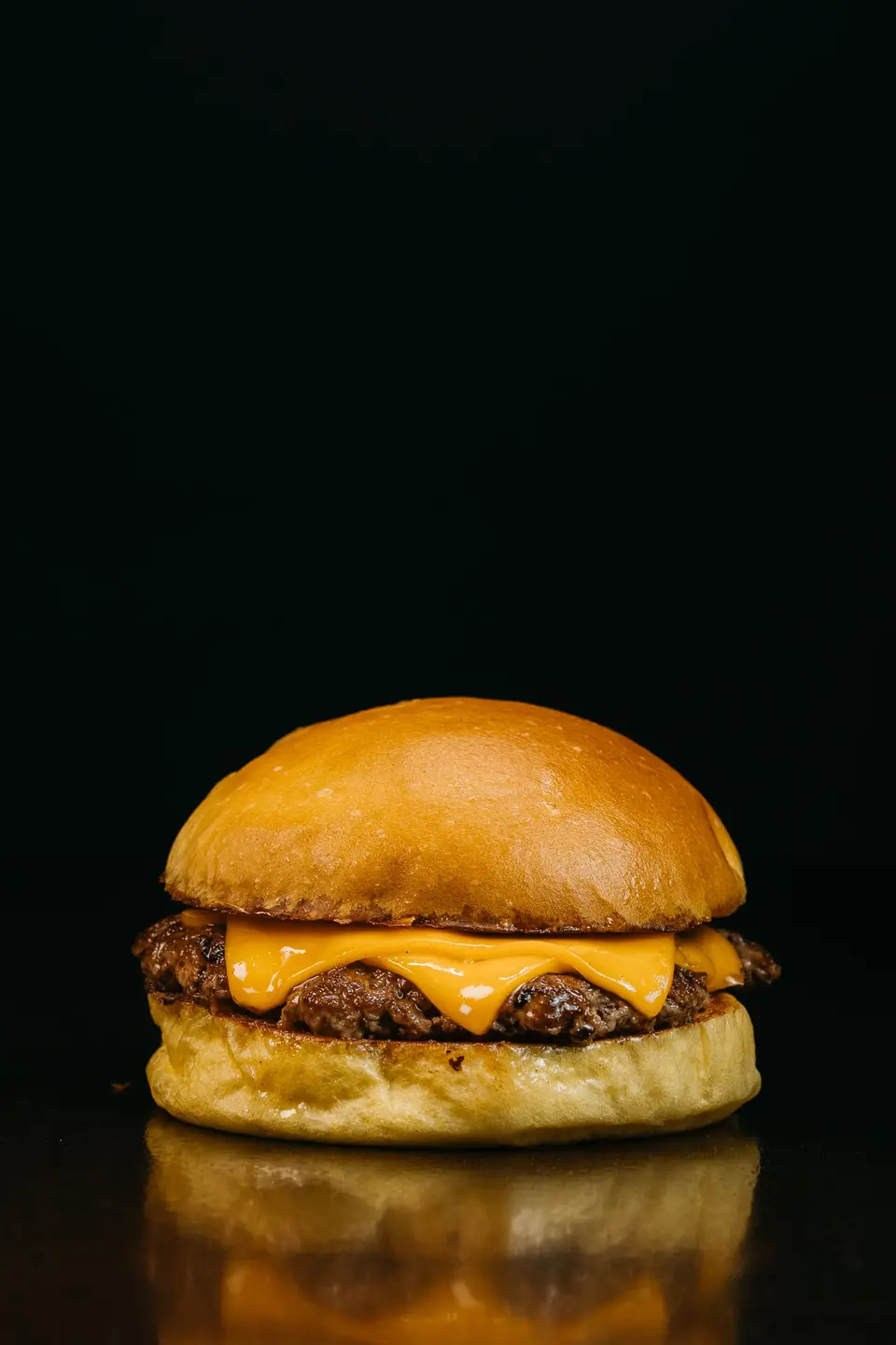 Single cheeseburger on a dark background