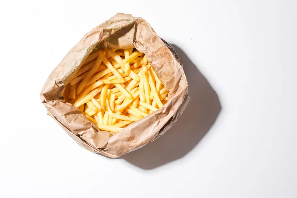 French fries in an open brown paper bag, seen from above