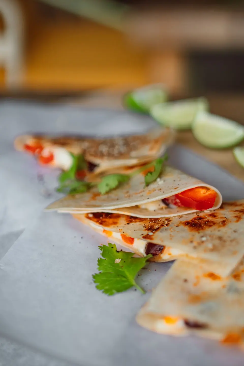 Sliced tortilla wraps with vegetables on white paper
